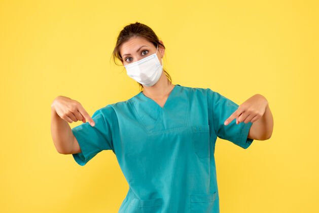 医疗正面图黄色背景上穿着无菌口罩医用衬衫的女医生肖像大流行成人