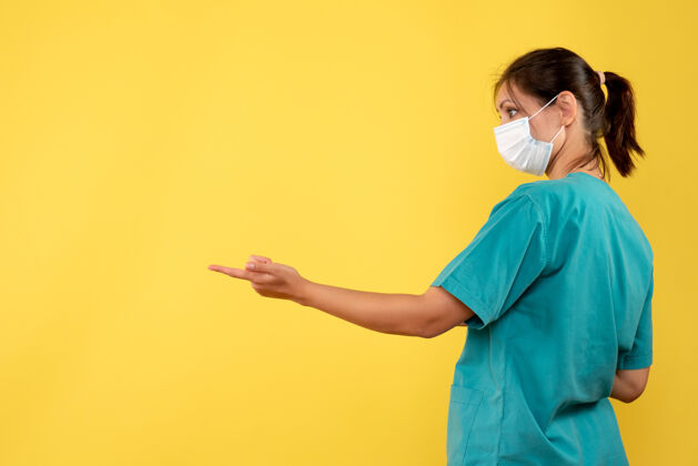 大流行正面图黄色背景上穿着医用衬衫和无菌口罩的女医生医疗前面人