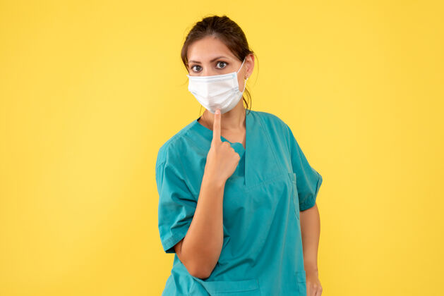 大流行正面图黄色背景上穿着医用衬衫和无菌口罩的女医生女医生健康病毒