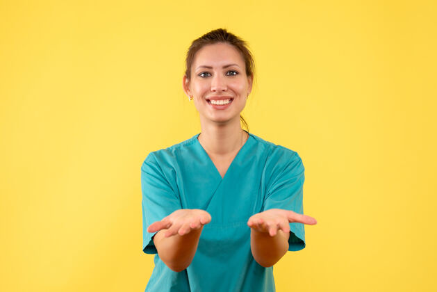 人前视图黄色背景上穿着医用衬衫的女医生成人女医生专业