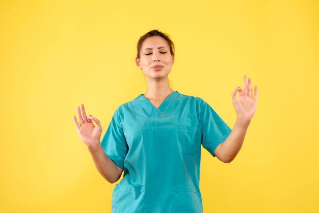 黄色前视图穿着医用衬衫的女医生在黄色背景上冥想成人肖像护士