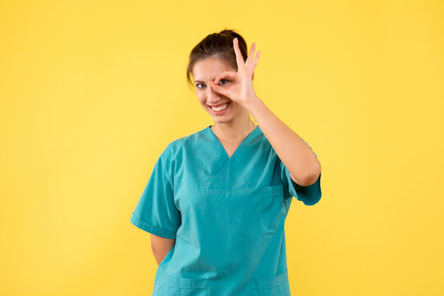正面前视图黄色背景上穿着医用衬衫的女医生病毒人女医生