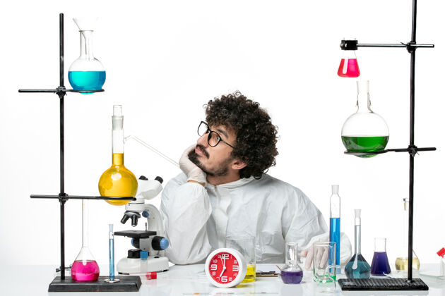 医生正面图身着特殊套装的年轻男科学家在白墙上做梦视图化学梦想