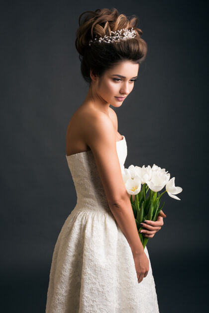 头发穿着婚纱的年轻漂亮时髦的女人美丽花束时尚