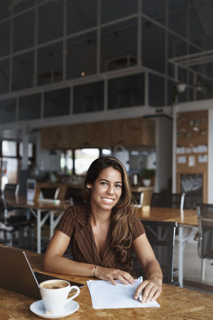 笔记本电脑成功的西班牙裔女性微笑着在咖啡馆工作咖啡企业家咖啡馆
