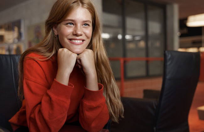 画像年轻漂亮的红发女学生的画像 坐在扶手椅上 靠在胳膊上微笑着学术红发学生