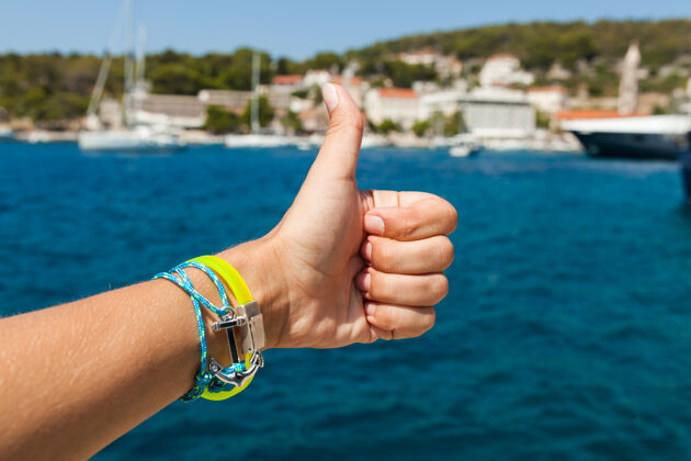 旅游在海上展示拇指向上的手势女性特写夏天