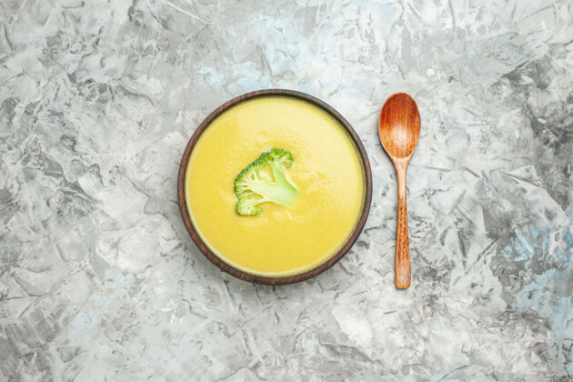 果汁俯瞰图奶油西兰花汤在一个棕色的碗和勺子在灰色的桌子上新鲜头顶汤碗