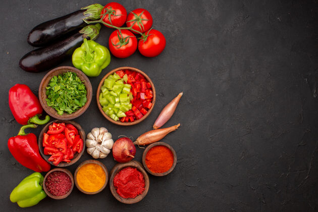 蔬菜顶视图新鲜蔬菜与绿色和不同的调味品对灰色桌餐沙拉健康食品蔬菜饮食香料背景
