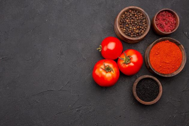 水果顶视图不同的调味料配上新鲜的红西红柿深色背景餐沙拉健康调味料番茄不同饮食