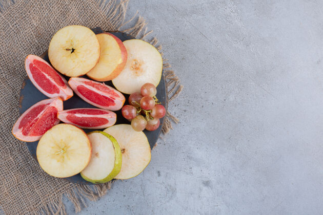 串在大理石背景的木板上放上一小串葡萄和梨子片美味美味柚子