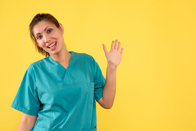 黄色前视图黄色背景上穿着医用衬衫的女医生病毒微笑肖像
