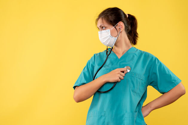 健康前视图穿着医用衬衫 戴着黄色背景听诊器的面罩的女医生黄色大流行正面