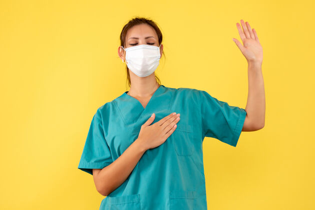 医疗前视图穿着医疗衬衫和面罩的女医生在黄色背景上骂人病毒医生健康