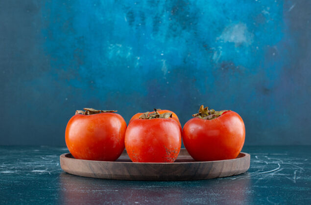 柿子美味的熟柿子放在木盘上有机盘子农业