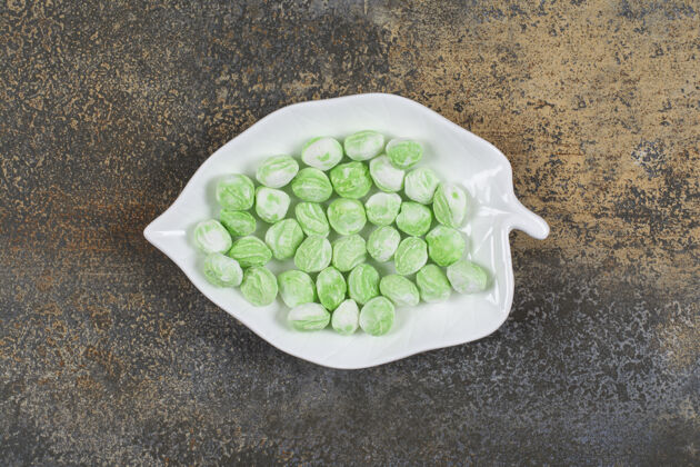 薄荷绿色薄荷醇糖放在叶子形状的盘子里薄荷糖果香料