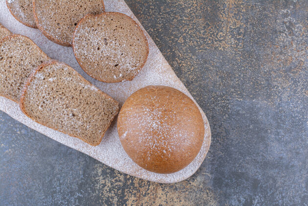 切片棕色面包片捆在大理石表面的木板上膳食酵母面包