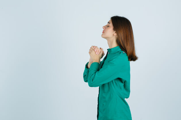 千禧年的心灵身穿绿衬衫的年轻女性双手合十祈祷 看上去充满希望扣地平线心灵