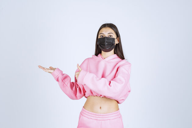 护理穿着粉色睡衣和黑色面具的女孩指着左边医学细菌治疗