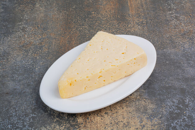 奶酪把一片黄奶酪放在白盘子里盘子美味有机