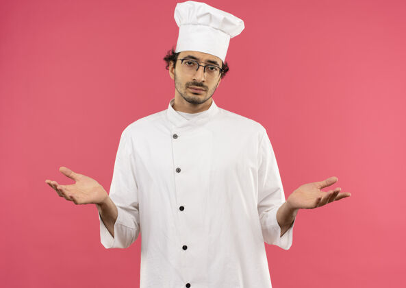 穿着年轻的男厨师穿着厨师制服 戴着眼镜 表现出什么样的姿态烹饪男士手势
