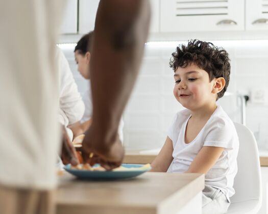 童年小男孩正在吃他爸爸准备的早餐家庭爱人