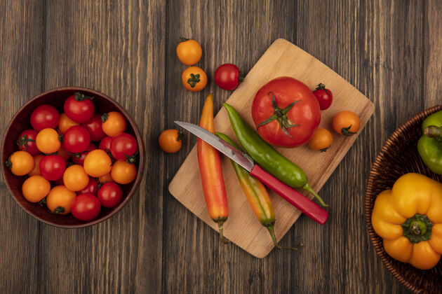 木材新鲜西红柿的顶视图在一个木制的菜板上 长辣椒用刀 樱桃西红柿放在一个木制的碗上 甜椒放在木制的桶上厨房番茄食宿