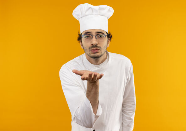 男人年轻的男厨师穿着厨师制服 戴着眼镜 露出亲吻的姿势手势男性表演