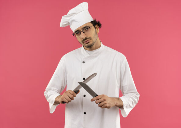 厨师年轻的男厨师穿着厨师制服 戴着眼镜 拿着切肉刀年轻烹饪男性