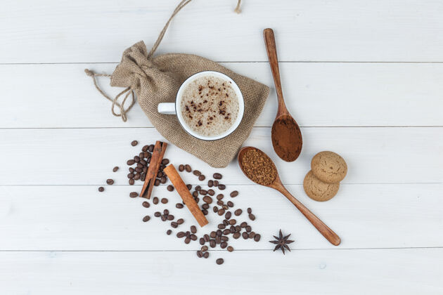 拿铁一套磨碎的咖啡 香料 咖啡豆 饼干和咖啡在一个木袋背景上的杯子顶视图种子套装豆类