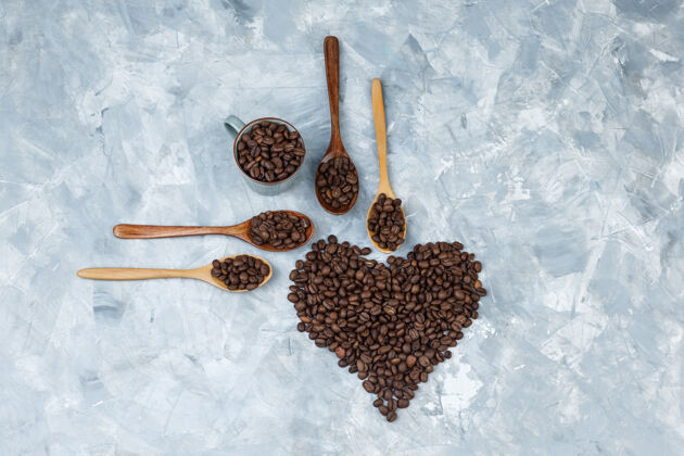 配料顶视图咖啡豆在木制勺子和灰色石膏背景杯水平浓缩咖啡质地自然
