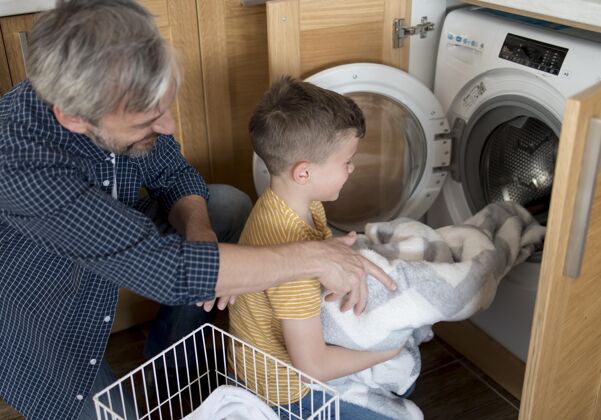 父母中等身材的男人和男孩在洗衣服洗衣店室内水平