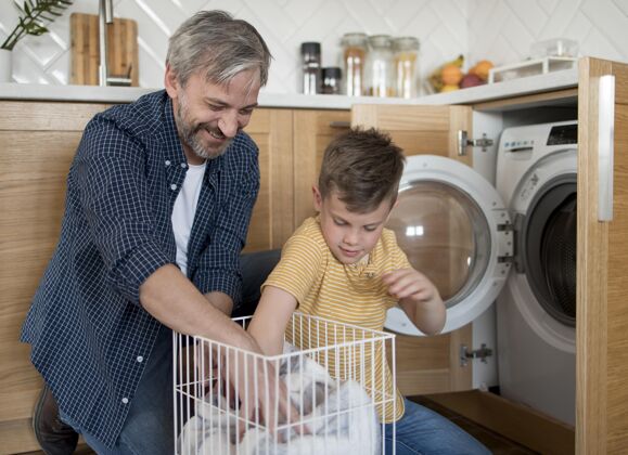 水平中枪男人和儿子在洗衣服家庭室内洗衣店