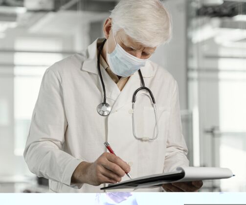 实验室戴着医用面罩的医生在检查他的笔记健康医生保健