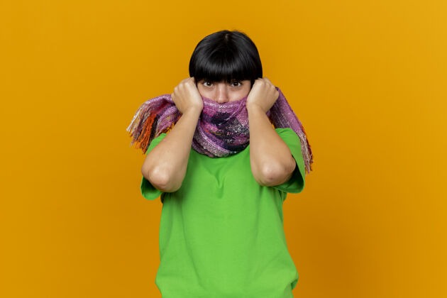 印象印象深刻的年轻病高加索女孩戴着围巾捂着嘴用围巾抓着围巾隔离在橙色墙上的复制空间围巾疾病盖