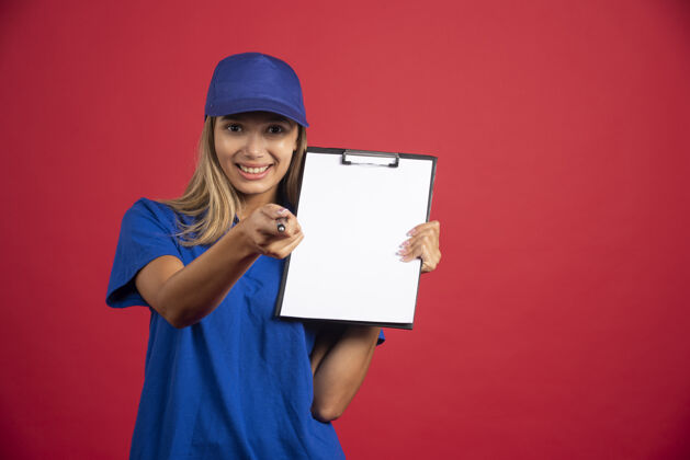 女士穿着蓝色制服的年轻女子拿着剪贴板 用铅笔指着摄像机女人女孩模型