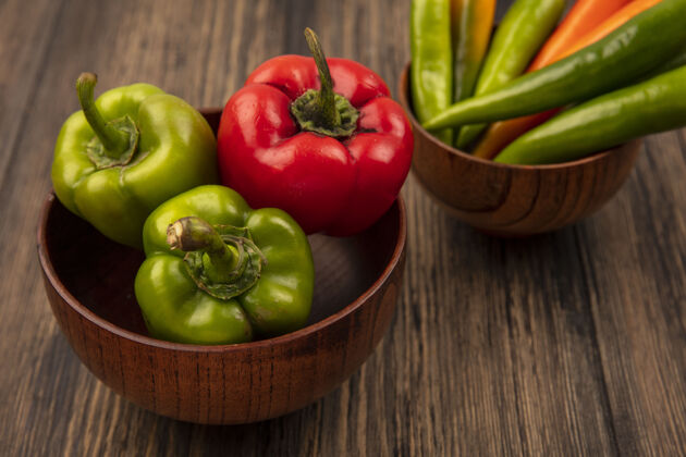 一餐顶视图新鲜的绿色和红色甜椒在一个木制的表面木碗蔬菜新鲜碗