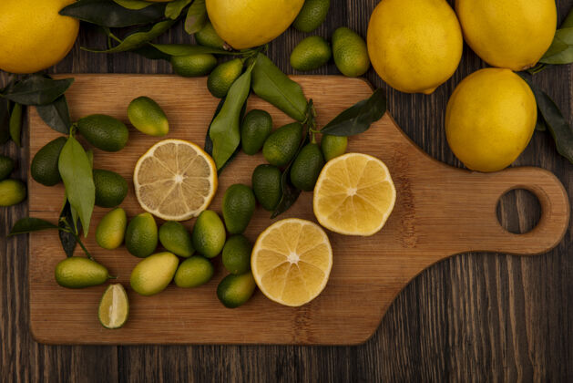 美味顶视图富含维生素的水果 如柠檬和金盏花在木制厨房板上的木制表面人水果食物
