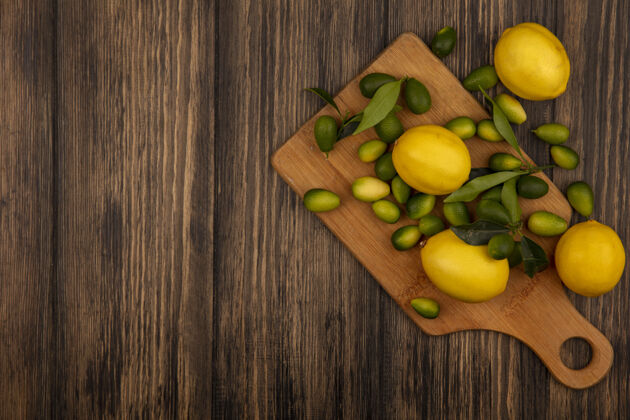 水果顶视图彩色水果 如柠檬和金盏花木厨房板上的木制表面复制空间五颜六色素食人