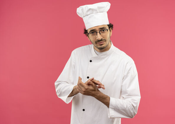 烹饪高兴的年轻男厨师穿着厨师制服和眼镜手牵手在一起厨师一起年轻