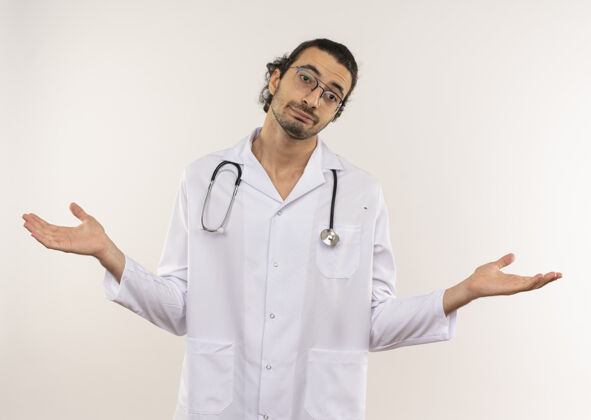男人困惑的年轻男医生戴着眼镜穿着白袍用听诊器摊开双手男性长袍眼镜