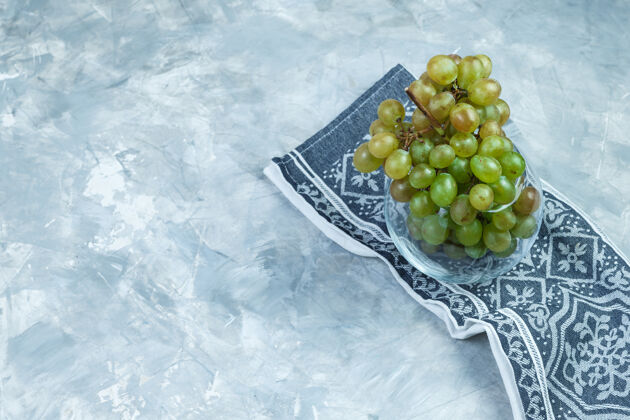 串把绿色的葡萄平放在玻璃罐里 背景是灰色的厨房毛巾水平葡萄酒营养水平