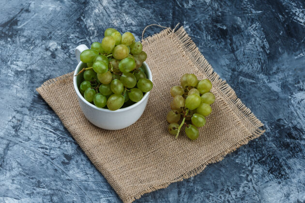 食物高角度观看绿色葡萄在白色杯子上的垃圾和布袋背景水平葡萄饮食营养