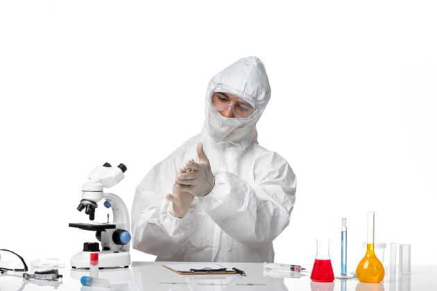 病毒正面图：男医生穿着防护服 戴着口罩 坐在一片空白处医药诊所正义