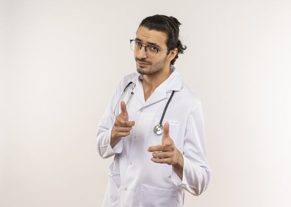 男人年轻的男医生戴着眼镜 穿着白色长袍 听诊器显示你的手势年轻眼镜长袍