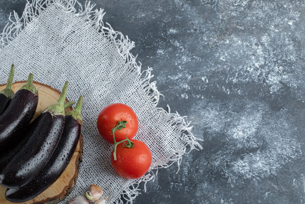 茄子新鲜的有机蔬菜紫色茄子放在木板上 配番茄和大蒜乡村美食膳食