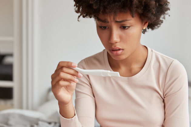 睡衣非洲发型的女人面临严重问题 不满意怀孕测试人测试女性