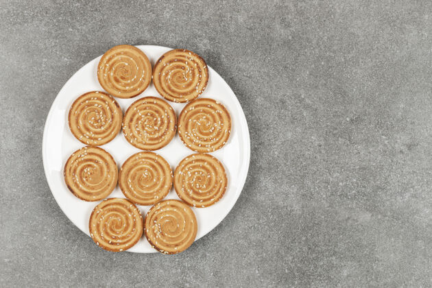 脆一盘美味的圆饼干放在大理石表面黄油小吃饼干