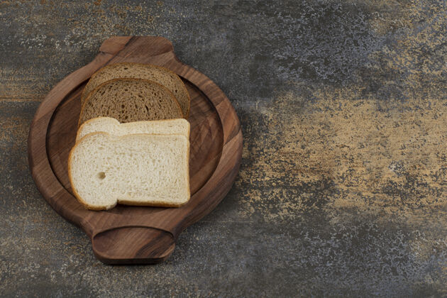 新鲜自制的黑白面包放在木板上吐司自然美味