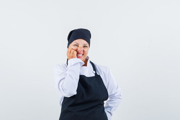 肖像女厨师穿着制服 围裙手放在脸颊上 看起来很可爱 前视图围裙手黑发